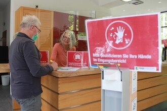 Ein Bild, dass man in Zeiten von Corona kennt: Veränderte Abläufe, Desinfektionsmittel und Regelungen zum Abstand ermöglichen wie hier im Nationalpark-Tor Heimbach ab sofort wieder touristische Beratung. (Foto: Nationalparkverwaltung Eifel/M. Weisgerber)