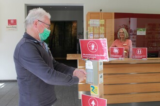 Was einmal ein Wegweiser war, wurde kurzerhand zum Desinfektions-Spender umfunktioniert. Das Servicepersonal freut sich, Gäste der Erlebnisregion wieder persönlich beraten zu dürfen. (Foto: Nationalparkverwaltung Eifel/M. Weisgerber)